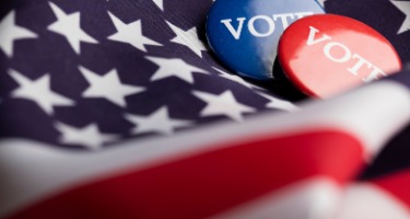 Close-up of an American flag with pins marking votes