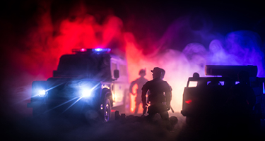 Police and emergency vehicles at night in smoke