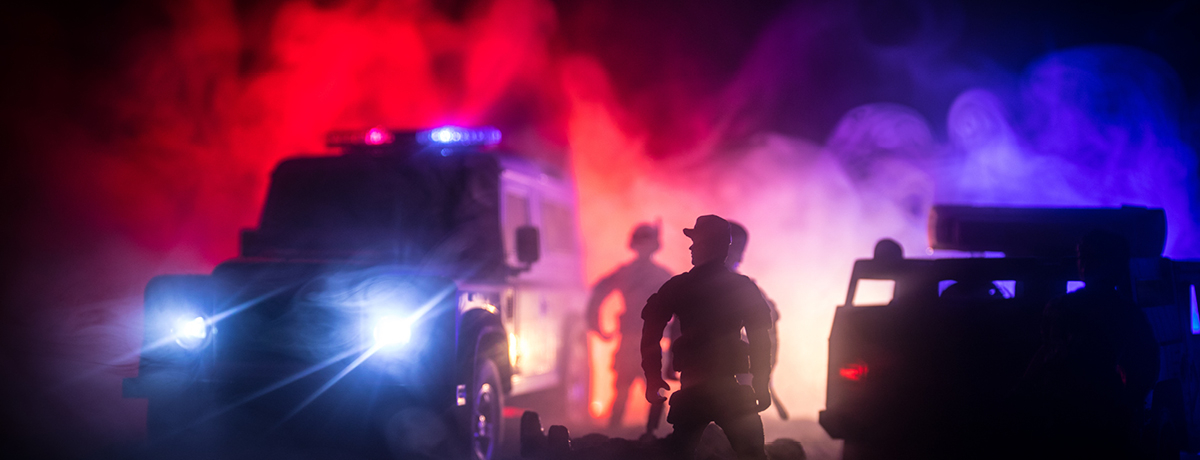 Police and emergency vehicles at night in smoke