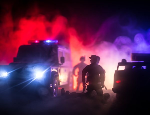 Police and emergency vehicles at night in smoke