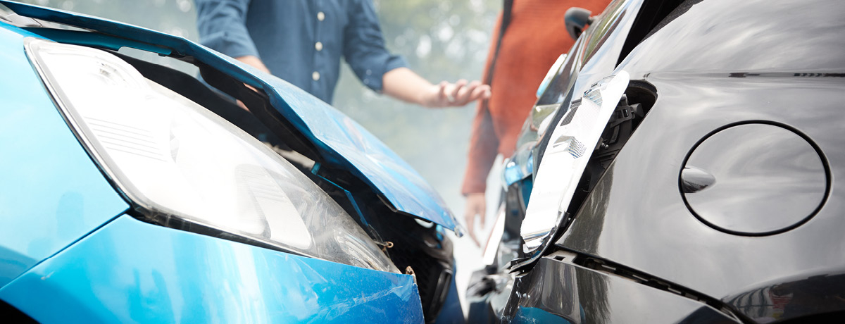 Blue car and grey car crashed into each toher with woman and man standing beside them talking