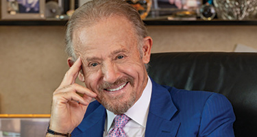 Lawyer smiles and poses for a picture in a blue suit