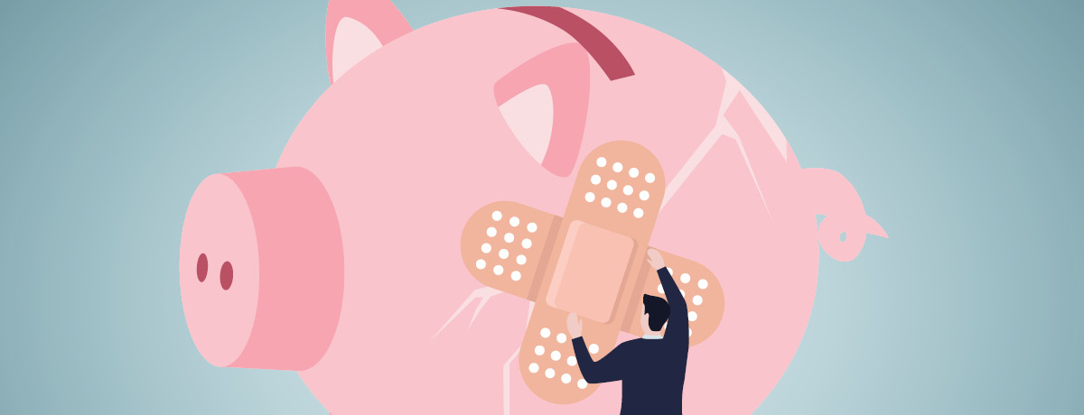 Large cracked piggy bank with person putting Band-aids on cracks