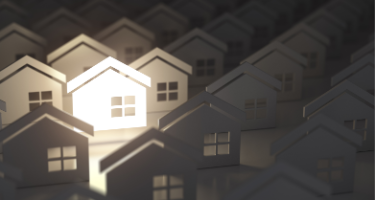 Multiple houses all in a row with one house lit by a spotlight