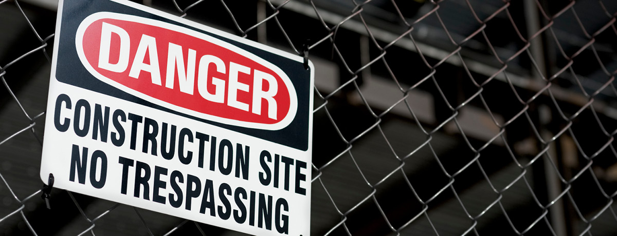 Danger construction site no trespassing sign on fence