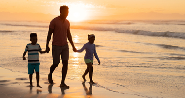 Family walking on the beach at sunset