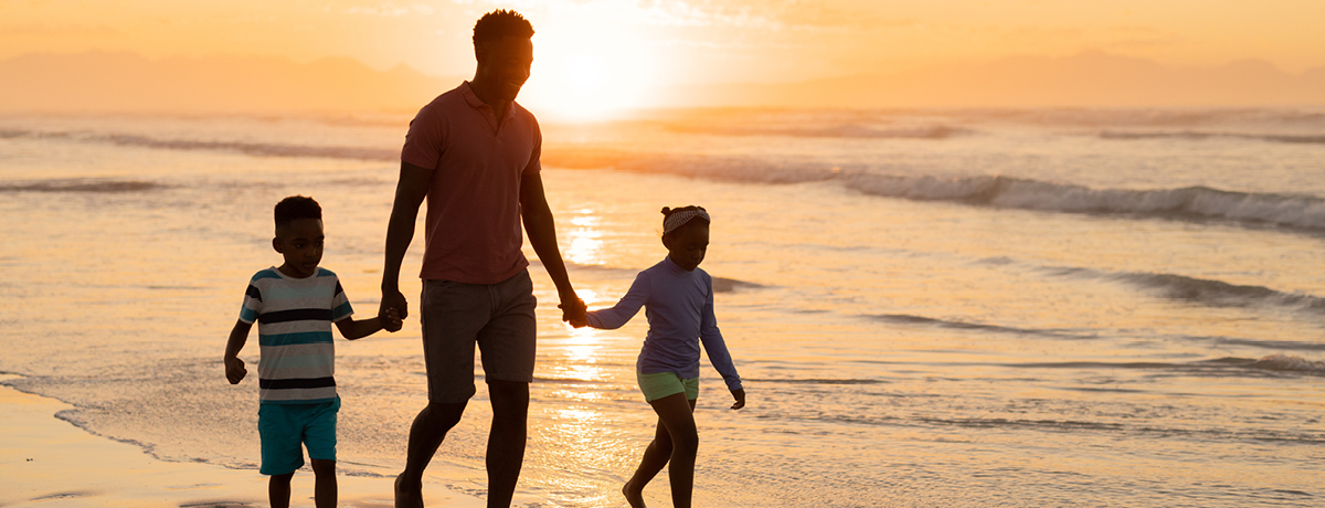Family walking on the beach at sunset