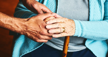 Elderly couple holding hands discussing the future
