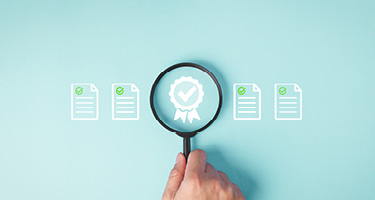 Magnifying glass over a ribbon icon, representing legal compliance