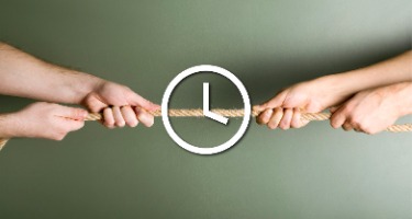 Two people tug a rope with a clock symbol in the middle of the rope