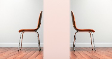 Wall separating two chairs on hardwood floor and a white wall