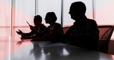 Three attorneys sitting in chairs at table 