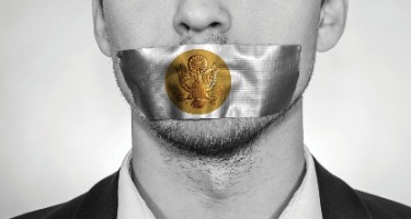Businessman with silver duct tape with the bronze presidential seal on his mouth