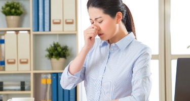 Businesswoman is allergic to work with succulent and binders and blue folders