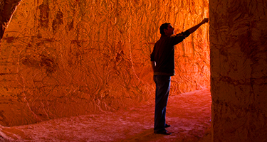 Man pointing to cave wall