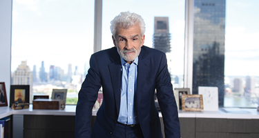 Man in suit leaning forward on desk