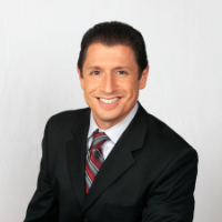 Headshot of man with dark hair in black suit