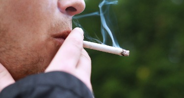 Close up of a man's mouth smoking a cigarette.