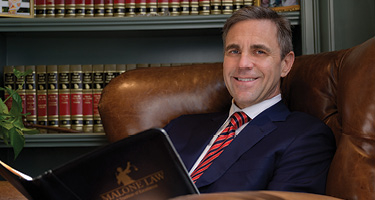 Lawyer sitting in a chair with a book posing for photo