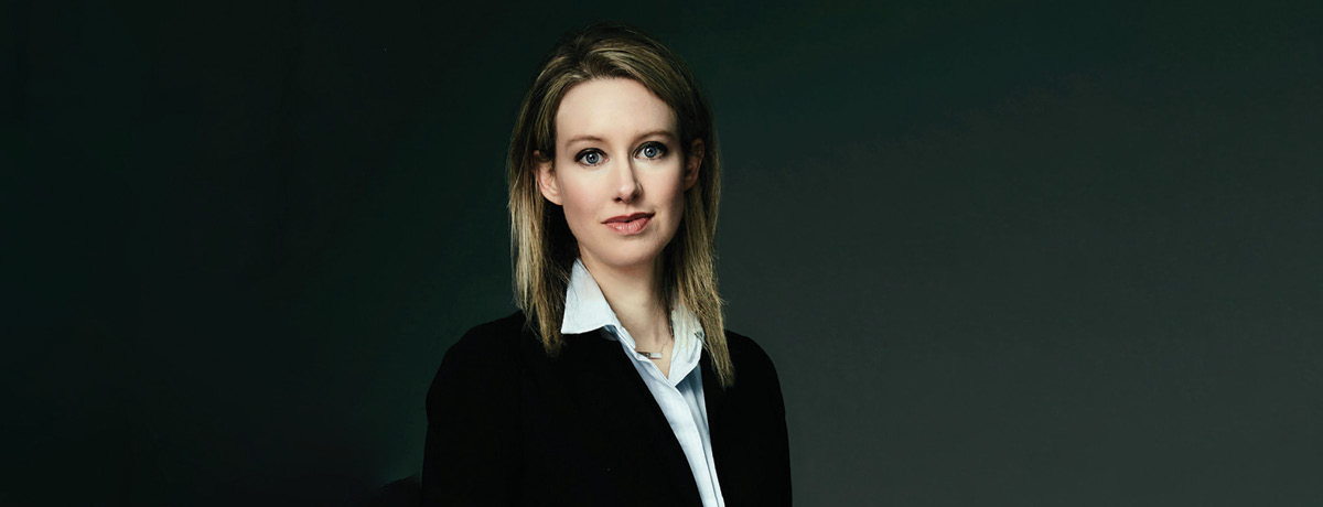 Woman in suit pictured alone with black background