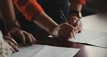 Two people signing documents