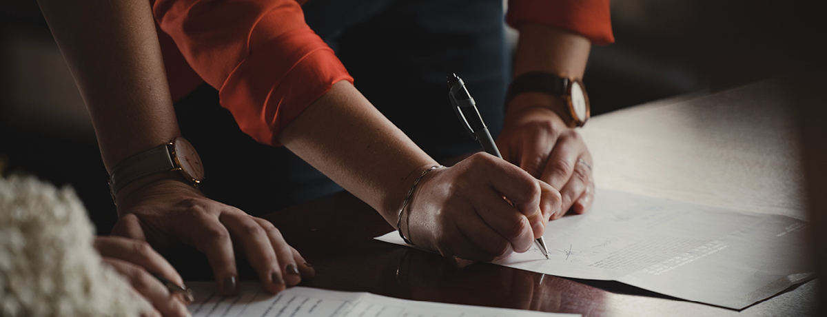 Two people signing documents