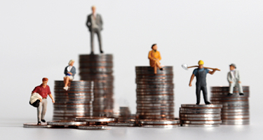 Small figurines stand on stacks of coins