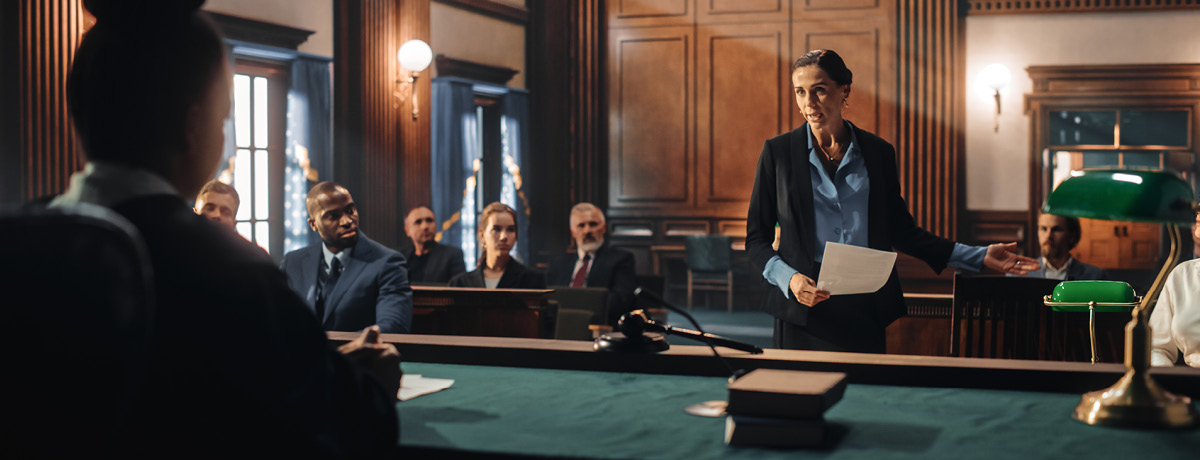 Lawyer speaking in courtroom with crowd and judge in the foreground