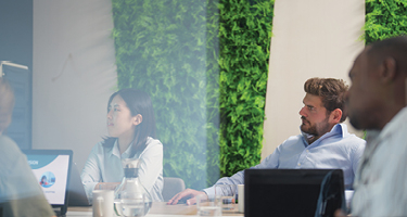 Two individuals in business attire sitting in conference room