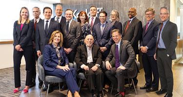 Group of suited lawyers gather for a picture