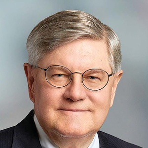 Lawyer wearing glasses and suit as he poses for headshot
