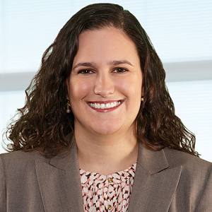 Suited woman with dark hair smiling