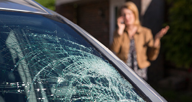 Woman on phone looking at cracked windshield