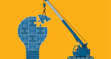 Orange background with blue construction lightbulb with puzzle pieces 