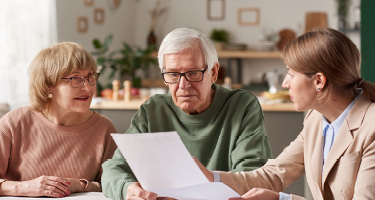 Older couple reviewing document with young woman