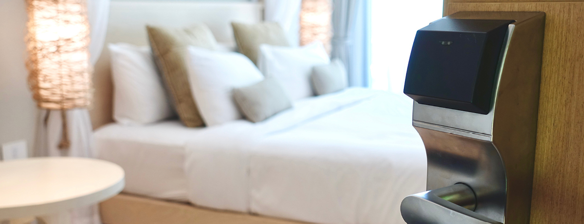 Door opening to a hotel room showing a neatly made bed