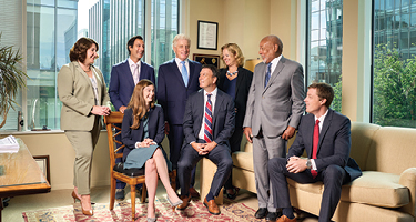 Several lawyers sitting and standing in a group in office