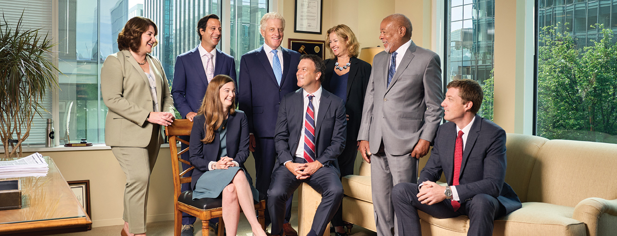 Several lawyers sitting and standing in a group in office