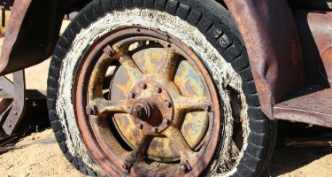 Rusted tire and rim illustrating hazards from defective vehicle parts.