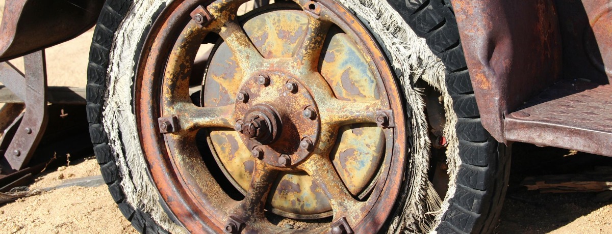 Rusted tire and rim illustrating hazards from defective vehicle parts.