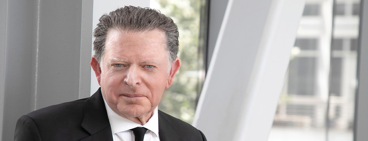 Man in black suit poses for lawyer headshot