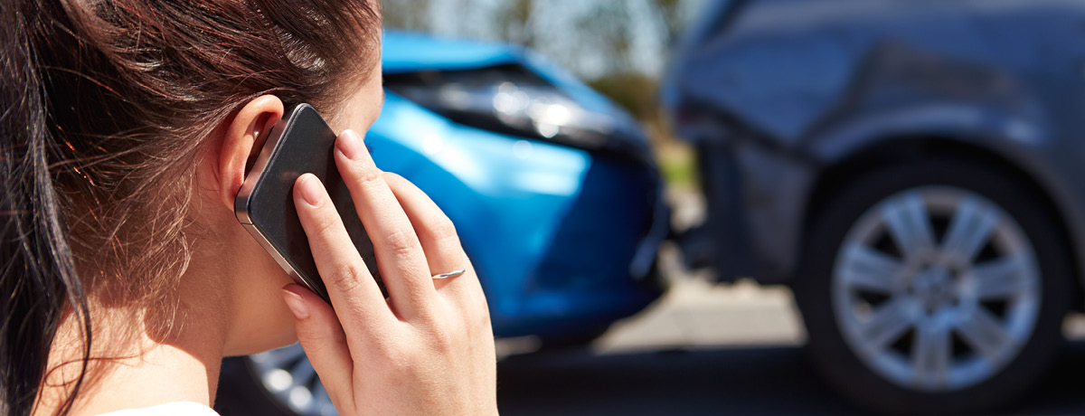 Person Using Cellphone After Car Accident