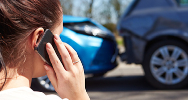 Person Using Cellphone After Car Accident