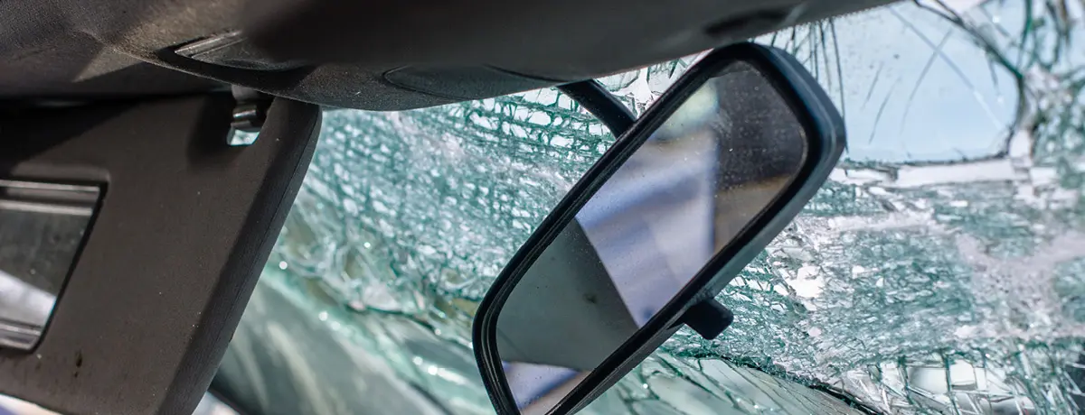 Shattered windshield and damaged interior of a car after a collision