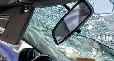 Shattered windshield and damaged interior of a car after a collision