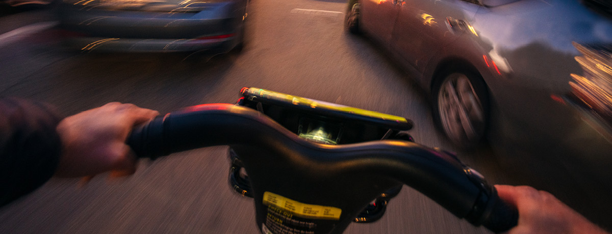 Blurry Cyclist POV Navigating Between Cars on Road