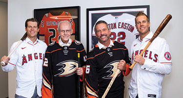 Four men wearing jerseys and holding sports gear