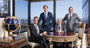 Group of lawyers pose at table with globe in forefront