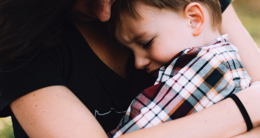 Woman hugs her crying child after a custody battle 