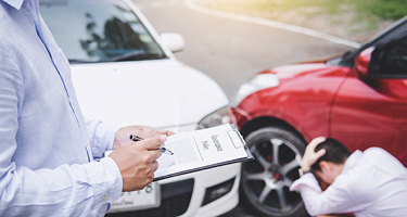 Figure with clipboard assesses the scene of an accident